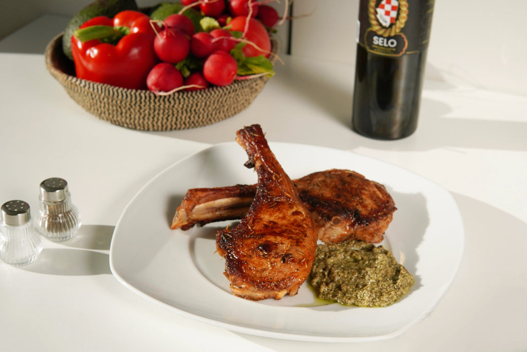 Juicy Lemon and Herb Grilled Chicken brushed with Croatian olive oil, garnished with fresh herbs and lemon slices, presented on a platter for a delightful and flavorful meal.